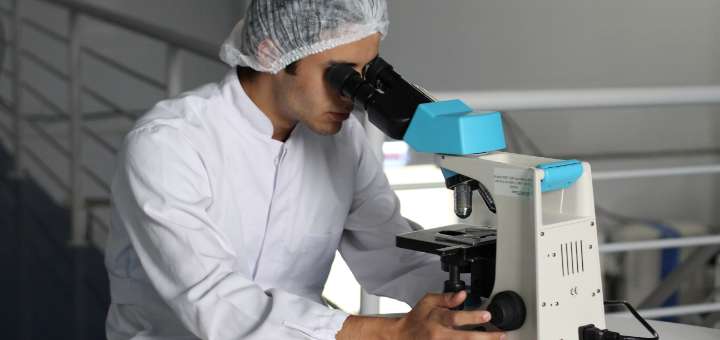 lab technician looking through a microscope